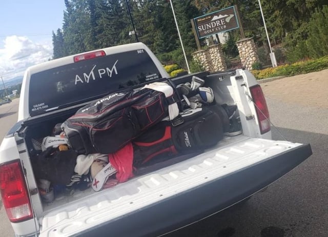 Truck bed of white Dodge Ram Limousine, filled with golf clubs